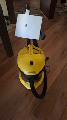 a yellow vacuum cleaner that is on a wooden floor