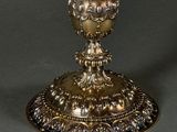 a gold vase on a stand with a black background