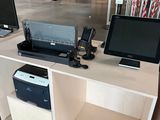 a desk with two computers and a printer on it