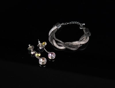 a close up of a bracelet and earring on a black surface