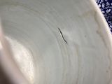 a close up of a white and blue bowl on a table