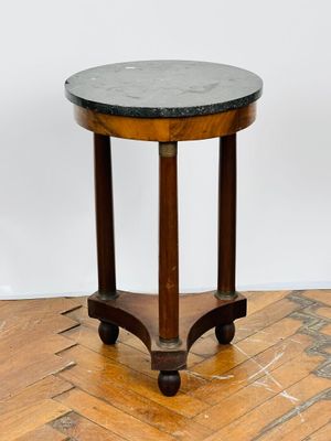 une photo représentant une petite table au plateau en marbre posée sur un parquet