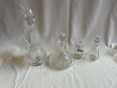 cinq bouteilles en verre et une carafe en verre posées sur une table