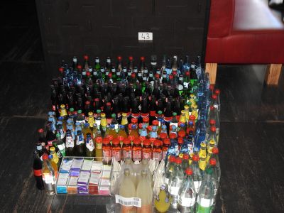 de nombreuses bouteilles et canettes de soda par terre