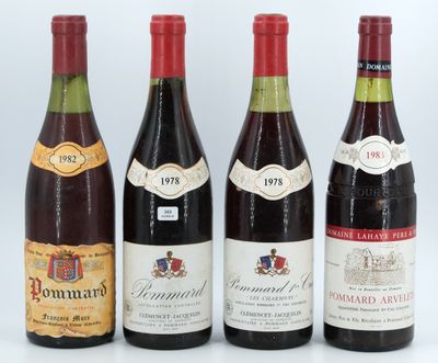 four bottles of wine are lined up on a white surface