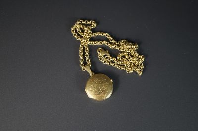 collier composé d'une pièce d'or suspendue à une chaîne, sur un fond noir