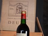 a bottle of wine sitting on a table next to a box of wine