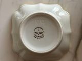 a small white plate with a clock on top of it