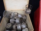 a wooden box filled with old metal objects on a table