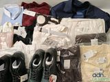 several pairs of shoes, shirts, pants, and other clothing are on display
