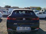 a black car parked in a parking lot with other cars