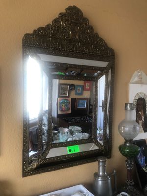 un miroir accroché au mur au-dessus d'un bureau sur lequel se trouve une lampe