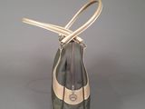 someone is holding a bag with a handle on a gray surface