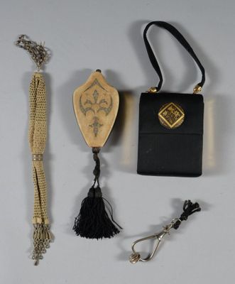 a small black purse with a tassel and other items on a table