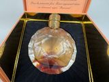 a glass perfume bottle in a box on a table