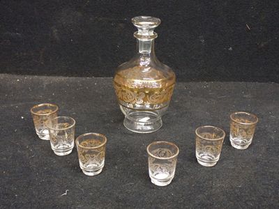 six verres et une carafe posés sur une table