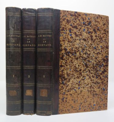 trois vieux livres posés l'un sur l'autre sur une surface blanche
