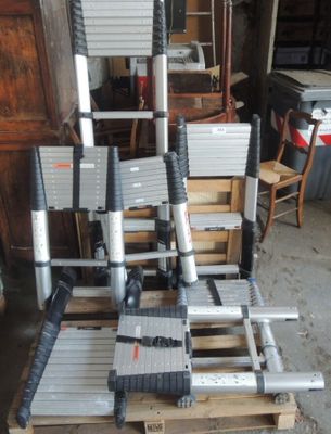 une pile d'échelles posée sur une palette dans un garage
