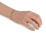 the hand of a woman is holding a gold bracelet