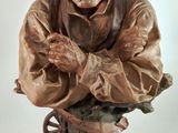 statue of an old man with a hat on his head and arms crossed