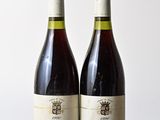 two bottles of wine sitting on top of a wooden table