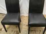 une paire de chaises de salle à manger en cuir noir avec des pieds noirs
