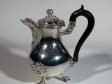 une théière en argent avec une anse noire sur un fond blanc