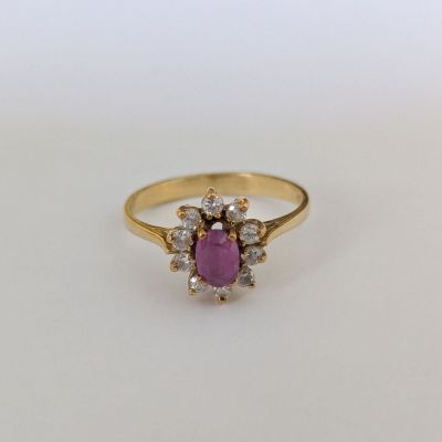 une bague en or sertie d'une pierre rose entourée de petits diamants blancs