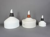 trois vases blancs et noirs posés les uns à côté des autres sur une surface grise