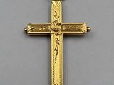 a close up of a gold cross on a gray surface