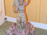 a statue of a woman holding a vase on top of a table