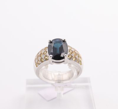 a close up of a ring with a blue sapphire and yellow diamonds