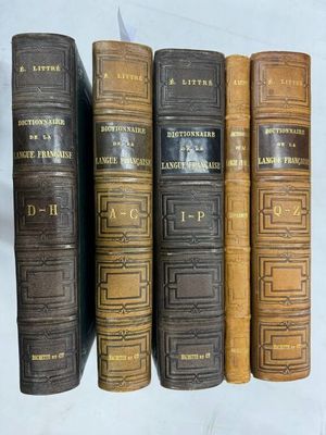 cinq vieux livres sont alignés sur une surface blanche
