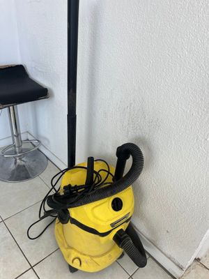 a yellow vacuum cleaner sitting on top of a tiled floor next to a bar stool