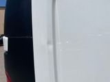 a white van with a red stripe parked in a parking lot