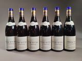 six bottles of wine are lined up in a row on a table