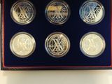 the four coin set is in a blue box on a white surface
