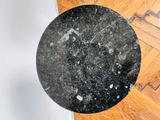 a black marble table top on a wooden floor