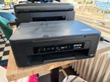 two printers sitting on top of a wooden table