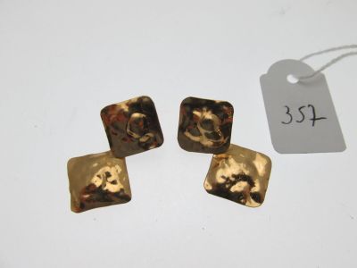 trois pièces de métal doré avec une étiquette sur un fond blanc