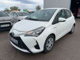 a white toyota yaris parked in a parking lot next to other cars