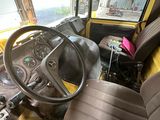 un camion jaune équipé d'un volant et d'un siège noir