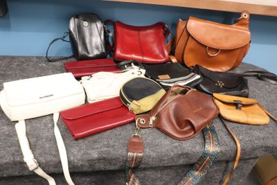de nombreux sacs à main de toutes sortes posés sur un banc dans une pièce