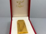 an image of a gold lighter in a red box on a table