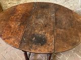 a wooden table with a wooden top on a brick floor