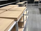 de nombreuses étagères en bois au milieu d'une pièce