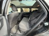 the back seats of a car with the door open and the driver ' s seat down