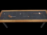 une petite table avec un plateau en carrelage noir sur fond noir