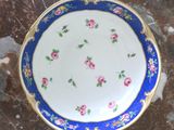 a blue and white plate with pink flowers on it
