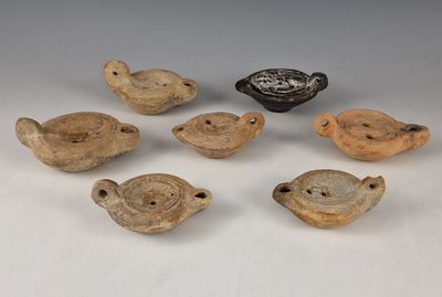 six pièces de poterie posées sur une table, à côté d'un bol